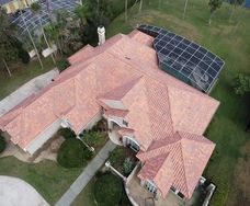 aerial view of new beige tile roofing on house in Orlando with screened in pool int he backyard
